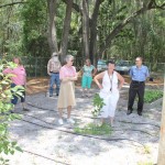 Mary Dewey leads a group after meeting to view here community garden.